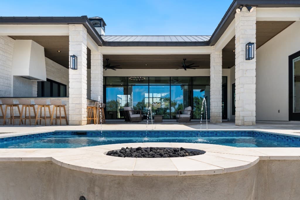 Wide view of a Pachanga pool, patio, and outdoor bar under a covered porch